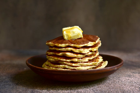 Homemade delicious pancakes with butter and maple syrup on a dark rustic background.の写真素材