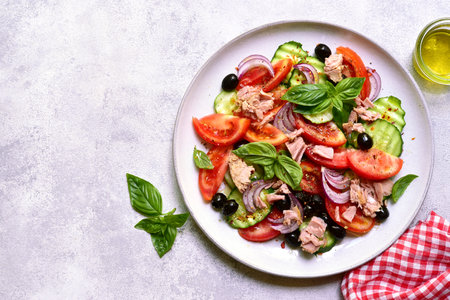 Fresh vegetable salad with tuna on a plate over light slate, stone or concrete background. Top view with copy space.の写真素材