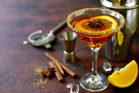 Cocktail with whiskey and orange syrup in a martini glass on a dark slate, stone or concrete background.の写真素材