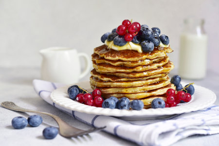 Banana pancakes with fresh berries for a breakfast on a light background.の写真素材