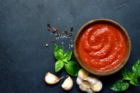 Spicy tomato soup or gazpacho on a dark slate, stone or concrete background. Top view with copy space.の写真素材