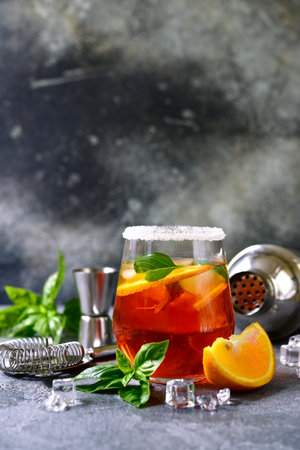 Orange cocktail with basil on a light gray slate, stone or concrete background.の写真素材