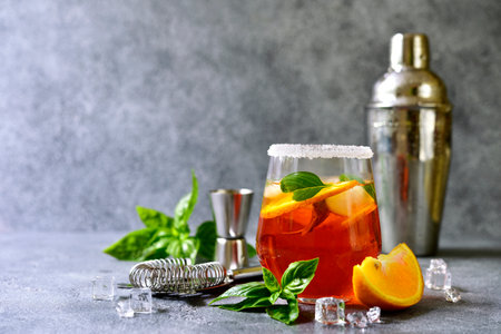 Orange cocktail with basil on a light gray slate, stone or concrete background.の写真素材