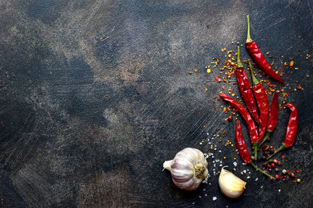 Chili pepper and garlic on a dark slate, stone or concrete background. Top view with copy space.の写真素材