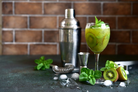 Kiwi cocktail with mint in a martini glasses on dark slate, stone or concrete background.の写真素材