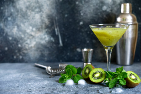 Kiwi cocktail with mint in a martini glasses on dark slate, stone or concrete background.の写真素材