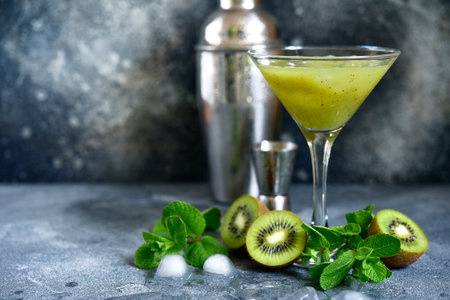 Kiwi cocktail with mint in a martini glasses on dark slate, stone or concrete background.の写真素材
