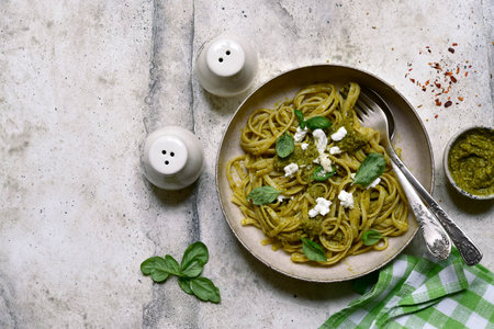 Pasta with pesto sauce, traditional dish of Italian cuisine on a light gray slate, stone or concrete background. Top view with copy space.の写真素材
