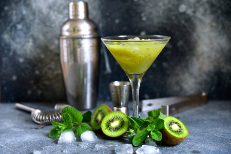 Kiwi cocktail with mint in a martini glasses on dark slate, stone or concrete background.の写真素材
