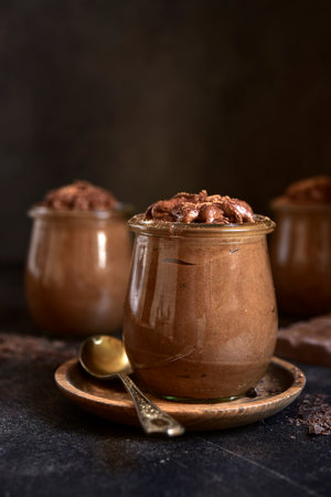 Delicious chocolate mousse in a vintage jars on dark slate, stone or concrete background.の写真素材