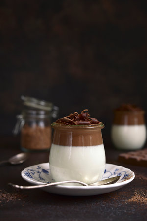 Panna cotta - traditional Italian cream dessert in a vintage jars on a dark slate, stone or concrete background.の写真素材