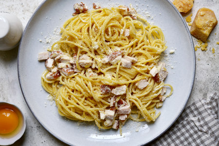 Spaghetti alla carbonara - traditional Italian pasta dish on a plate over light gray slate, stone or concrete background. Top view with copy space.の写真素材