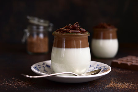 Panna cotta - traditional Italian cream dessert in a vintage jars on a dark slate, stone or concrete background.の写真素材