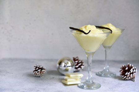 Festive delicious vanilla pudding with white chocolate in a glasses on light slate, stone or concrete background.の写真素材