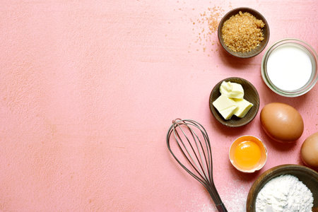 Food background with ingredients for baking on a rose slate, stone or concrete table. Top view with...