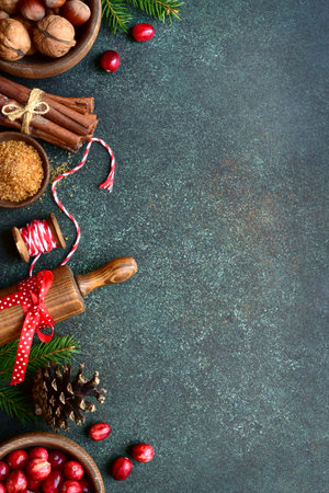 Christmas baking background with ingredients for making cake or biscuit on a dark green slate, stone or concrete table. Top view with copy space.の写真素材