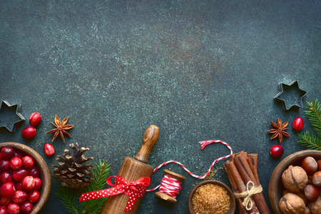 Christmas baking background with ingredients for making cake or biscuit on a dark green slate, stone or concrete table. Top view with copy space.の写真素材
