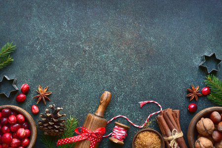 Christmas baking background with ingredients for making cake or biscuit on a dark green slate, stone or concrete table. Top view with copy space.の写真素材