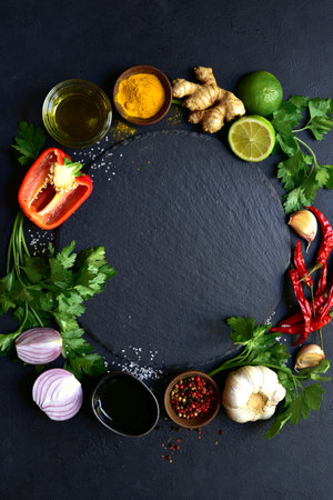 Food background with ingredients for cooking on a black slate, stone or concrete table. Top view with copy space.の写真素材
