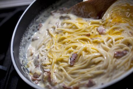 cooking spaghetti carbonara with bacon in panの写真素材