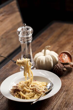 spaghetti hanging on a fork with garnishの写真素材