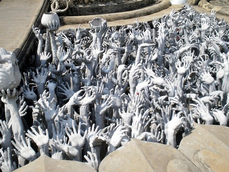 Chiang Rai: Wat Rong Khun, the white temple. Sculpture at the foot of the bridge of hands emerging from the ground. Photo taken in January 2014 during a stay in Thailand.のeditorial素材
