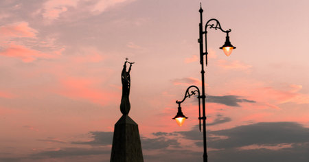 Statue and lamp with beautiful cloudy sky and a sunset