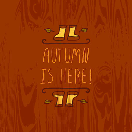 Hand-sketched typographic element with rubber boots, leaves and text on wooden background. Autumn is hereのイラスト素材