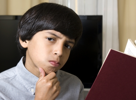 pensive boy reading a bookの写真素材