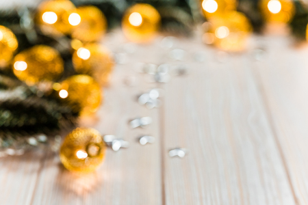 Christmas blurred background with a glowing garland golden bokeh on white wooden table. A beautiful holiday idea for postcards and posters. Free space, frameの写真素材