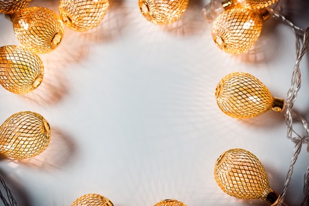 Christmas background with a luminous garland on white. A beautiful holiday idea for postcards and posters. Free space, golden frameの写真素材