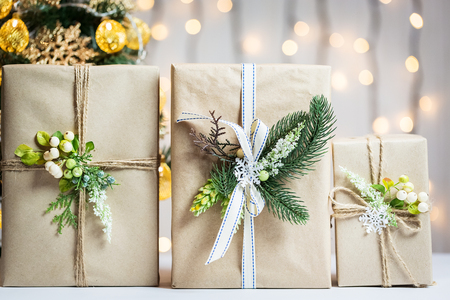 A Christmas tree decorated snowflakes and a garland with gift box on the background of a bokeh and white boards.の写真素材
