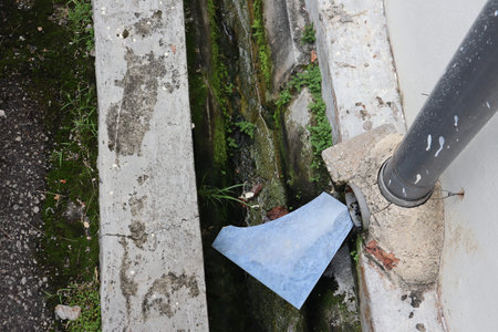 Water flows from a pipe on the street. The concept of water pollutionの写真素材