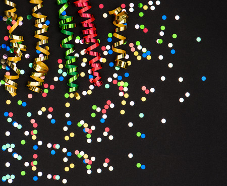 colorful streamer and confetti on black paper party decorationの写真素材