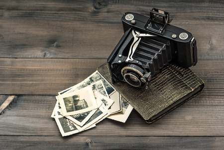 vintage camera and album with old photos on wooden table  nostalgic pictureのeditorial素材