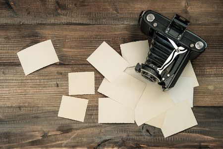 vintage camera and old photos on wooden background  nostalgic style pictureの写真素材
