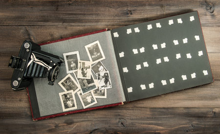 vintage camera and album with old photos on wooden table  retro style pictureのeditorial素材