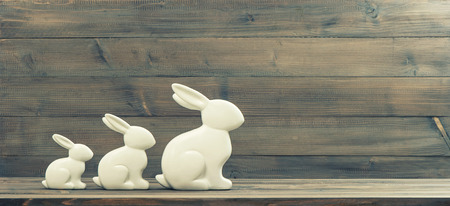 easter bunnies over rustic wooden background. retro style toned pictureの写真素材