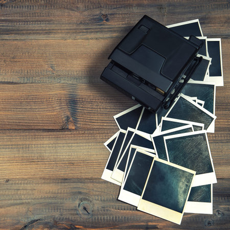 old photo frames and camera on rustic wooden . retro style toned picture