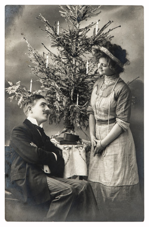 happy young couple celebrated with christmas tree. vintage picture with original film grain and blurの写真素材