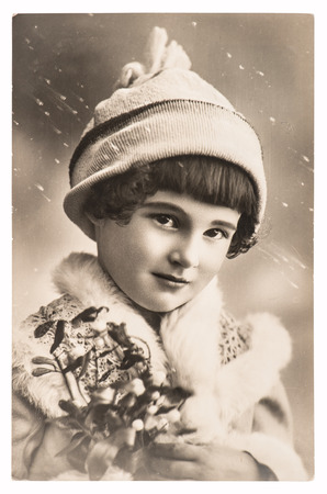 cute girl with christmas decoration and winter clothing. antique holidays greetings pictureの写真素材