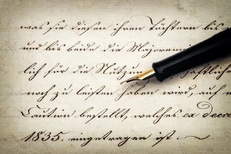 Old letter with calligraphic handwritten text and vintage ink pen. retro style toned paper backgroundの写真素材