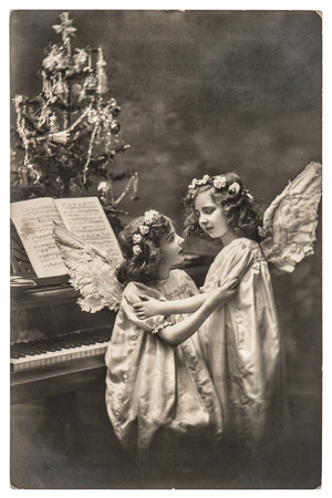 sweety angel girls with white wings and christmas tree. vintage picture with original film grain and blurの写真素材