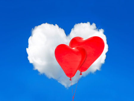 Two red balloons and heart shaped cloud in the perfect blue sky. Valentines Dayの写真素材
