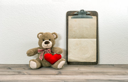 Teddy Bear with red heart and clipboard. Valentines Day backgroundの写真素材