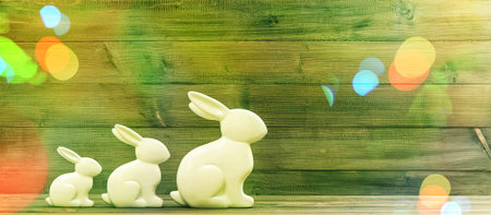Easter bunnies over rustic wooden background. Retro style toned picture with light leaksの写真素材