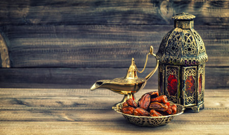 Ramadan lamp and dates on wooden background. Still life with oriental lantern. Vintage style toned...