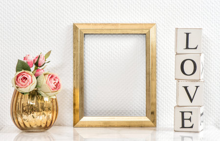 Picture frame and pink roses. Valentines Day concept. Mock up with golden frame and flowers with...
