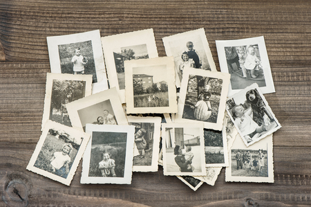 Old family photos on wooden table. Vintage picturesの写真素材