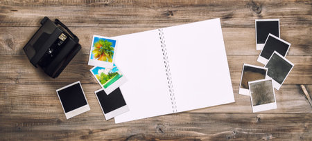 Open photo album book, camera, polaroid frames. Retro toned picture